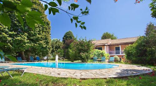 a swimming pool with a fountain in a yard at Villa Leda in Karousádes