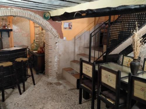 a room with a staircase and a table and chairs at El Soportalillo de la Fuente Vieja in Tendilla