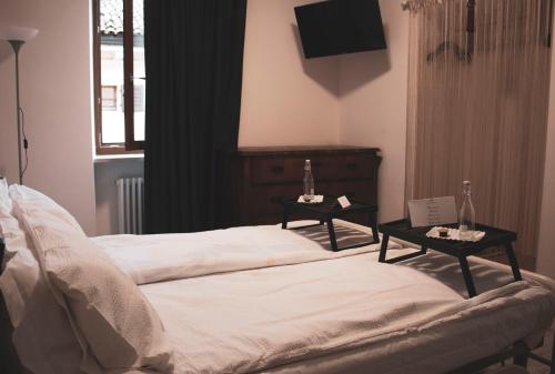 Un dormitorio con una cama con dos mesas. en B&B Alessandro, en Villa Lagarina