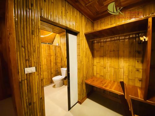 a bathroom with a toilet and a wooden wall at KLONGBON GARDEN HOME Koh Yao Yai in Ko Yao Yai