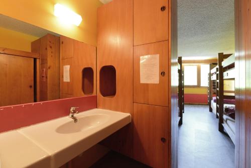 une salle de bain avec un lavabo et un miroir dans l'établissement Auberge de Jeunesse HI Séez, à Séez