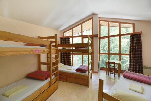 a room with three bunk beds and a table at Auberge de Jeunesse HI Séez in Séez