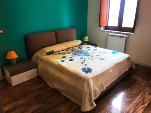 Un dormitorio con una cama con flores azules. en La casa dei gerani, en SantʼAgata