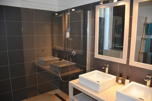 a bathroom with three sinks and a mirror at La Bastide rouge in Saint-Geniès-Bellevue