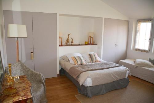 a bedroom with a bed and a couch and a chair at La Bastide rouge in Saint-Geniès-Bellevue