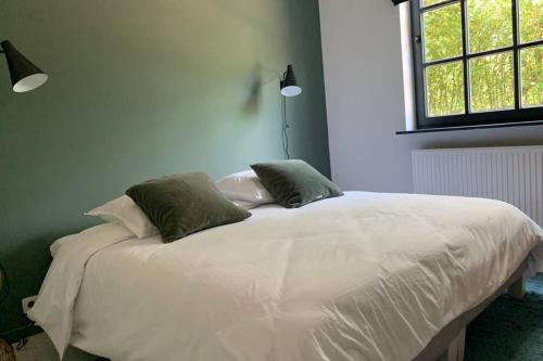 a white bed in a room with a window at Uccle, Pavillon Vert in Brussels