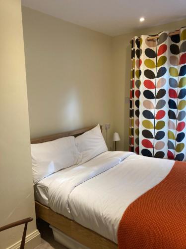 a bedroom with a bed and a colorful curtain at Newell Bistro and Rooms in Sherborne