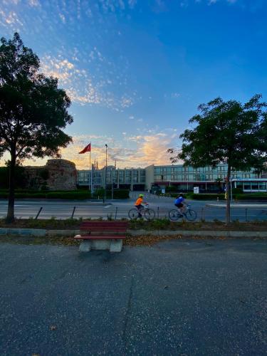 two people riding bikes and a bench in a parking lot at Kalyon Hotel Istanbul in Istanbul