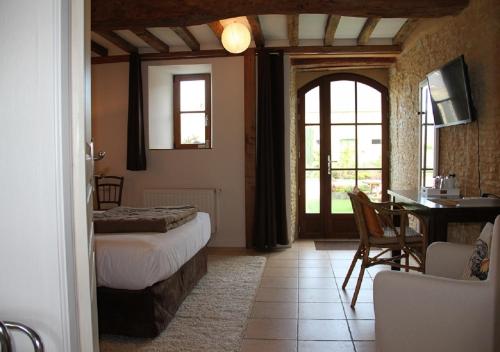 1 dormitorio con cama, mesa y escritorio en chambres d'hôtes de Létanville en Grandcamp-Maisy