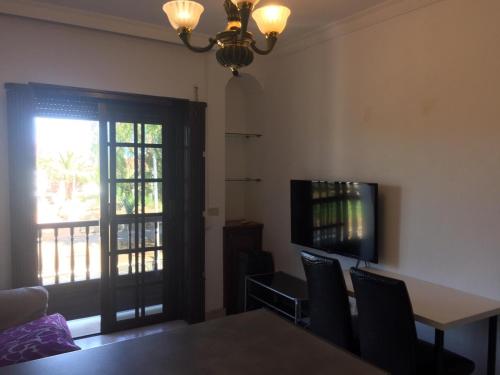 a dining room with a table and chairs and a television at Guajara loft-balcon in La Laguna