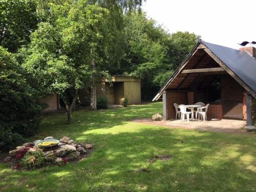 a yard with a cabin with a table and chairs at Mühlenweg Onkel Fiffi in Süderlügum