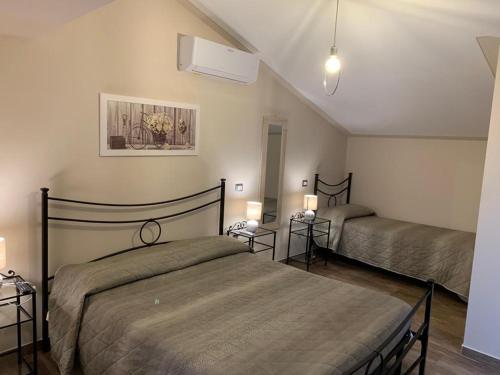 1 dormitorio con 2 camas y 2 lámparas. en B&B Il Casale en Foligno