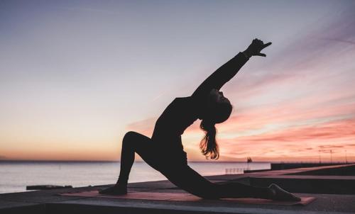 una mujer haciendo una pose de yoga frente al océano en Langre Wayve House, en Langre