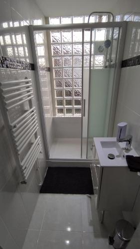 baño blanco con ducha y lavamanos en La Batisse de Saint-Chamond ( chambres ), en Saint-Chamond