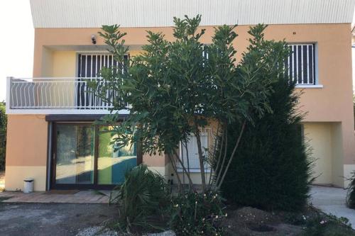 a house with a tree in front of it at Irigny: Maison calme à 10 minutes de Lyon in Irigny