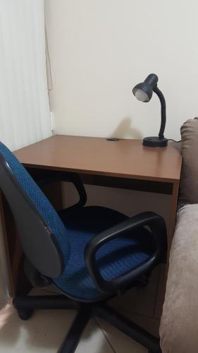 a desk with a chair and a lamp on it at Ótimo apartamento no Centro mobiliado e com garagem in Curitiba