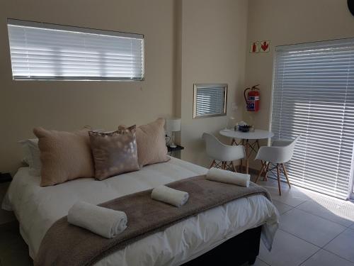 a bedroom with a large bed with a table and chairs at Sharon's House: Modern Self-Catering rooms in Cape Town