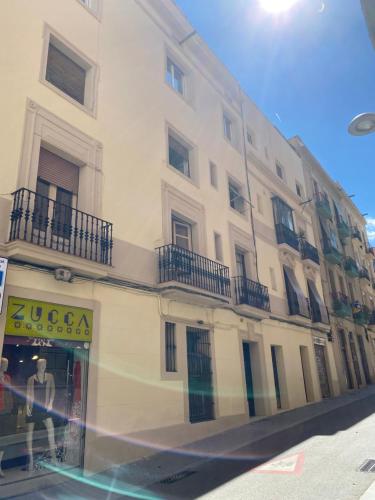 a tall white building with balconies on a street at Heart of Gracia in Barcelona