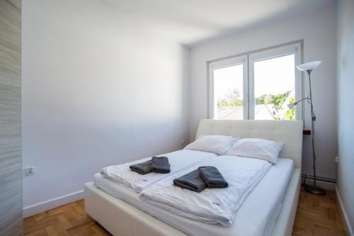 a white bedroom with a bed with towels on it at Apartamenty Robi in Kołobrzeg