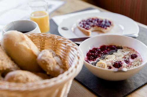 a table with a basket of breakfast food and a plate of doughnuts at Sepp & Hannis Suiten im Dorf in Neustift im Stubaital