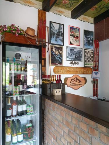 a bar in a restaurant with a refrigerator at Pensiunea Luna in Buşteni