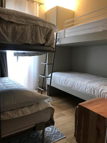 a room with two bunk beds and a table at Chalet Bizet - Limone 1400 in Limone Piemonte