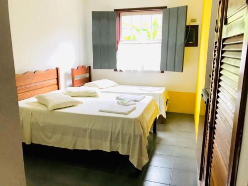 a room with two beds in a room with a window at Pousada Gabriela in Paraty