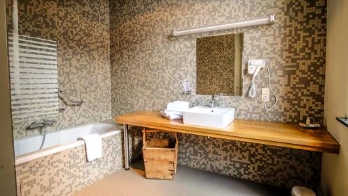 a bathroom with a sink and a bath tub at La Merveilleuse by Infiniti hôtel in Dinant