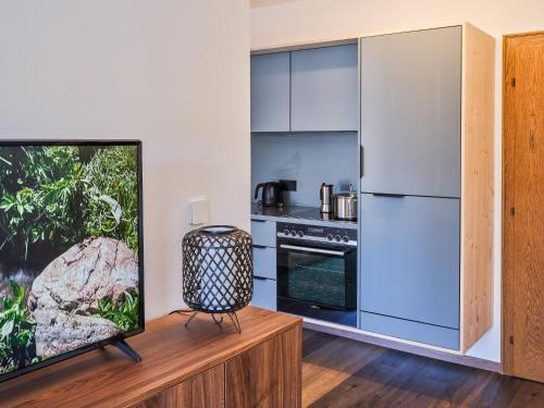 a kitchen with a refrigerator and a tv in a room at Ferien Seminar Retreat - Zugspitze in Leutasch