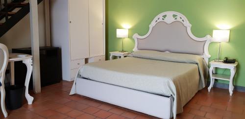 a bedroom with a large white bed and two tables at Art & Jazz Hotel in Catania