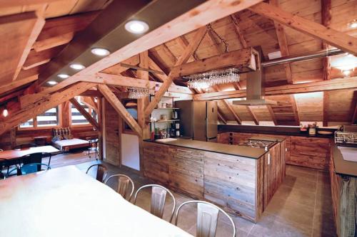 une grande cuisine avec des plafonds en bois, des tables et des chaises dans l'établissement chalet coup de coeur+véhicule 4*4 ; 9 places à dispo, à La Clusaz