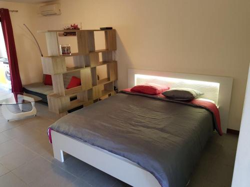 a bedroom with a bed and a book shelf at studio meublé Montjoly avec accès piscine in Rémire-Camp