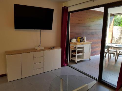 a living room with a flat screen tv on the wall at studio meublé Montjoly avec accès piscine in Rémire-Camp