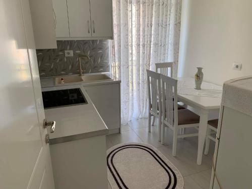 a kitchen with a table and a sink and a table and a table at Apartament Oresti in Korçë