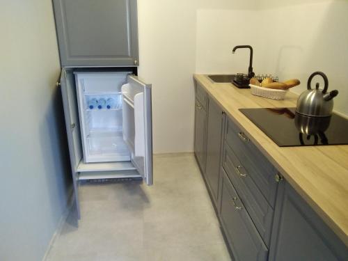 a kitchen with a refrigerator with its door open at SECESJA HOUSE in Oświęcim