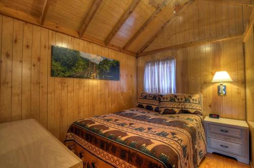 a bedroom with a bed in a wooden room at Riverbend Lodging in Bryson City