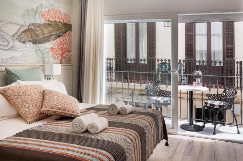 1 dormitorio con 1 cama y balcón con mesa en Sitgesnextdoor en Sitges