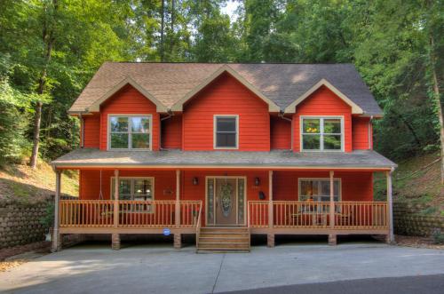 a red house with a large front porch at Gorgeous "Country Roads" by HoneyBearCabins 4BR 4BA, next to pool, easy drive, main strip location! in Pigeon Forge