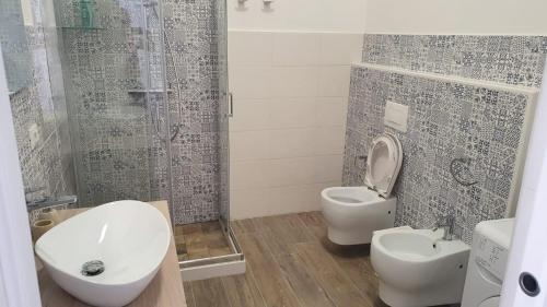 uma casa de banho com um WC, um lavatório e um chuveiro em A casuzza em Marzamemi