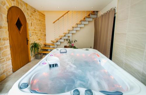 a large bath tub in a room with a staircase at Le Moulin d'Harcy in Lonny