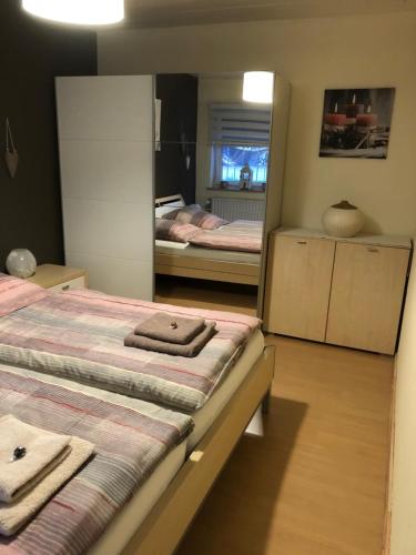 a bedroom with two beds and a mirror at Kleine Auszeit in Neunkirchen