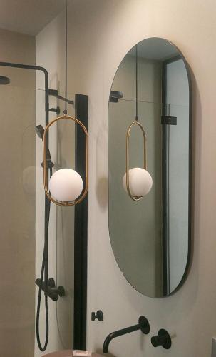a bathroom with two lights and a mirror at Luciani 33 luxury rooms in Salerno