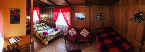a bedroom with a bed and a table in a room at Cabañas Armonía y Jardín de Orquídeas in Mindo
