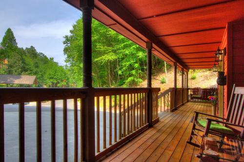 a wooden porch with a view of the water at Gorgeous "Country Roads" by HoneyBearCabins 4BR 4BA, next to pool, easy drive, main strip location! in Pigeon Forge