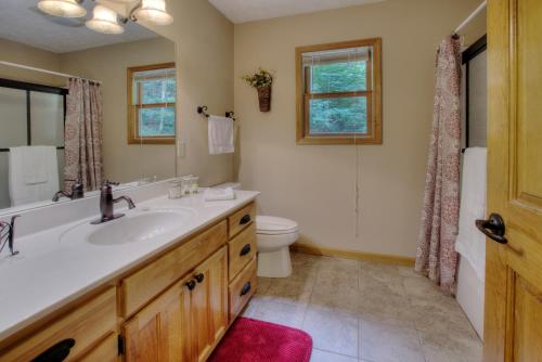 a bathroom with a sink and a toilet at Gorgeous "Country Roads" by HoneyBearCabins 4BR 4BA, next to pool, easy drive, main strip location! in Pigeon Forge