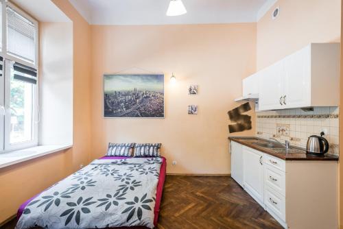 a small bedroom with a bed and a kitchen at Adam12 in Krakow