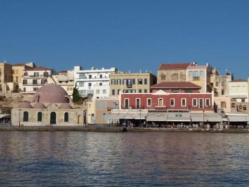 un grupo de edificios al lado de un cuerpo de agua en Marinos Suites, en La Canea