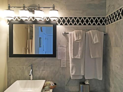 a bathroom with a sink and a mirror and towels at Morris House Hotel in Philadelphia