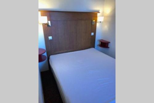 Dormitorio pequeño con cama con cabecero de madera en Appartement La Plagne soleil - Pied des pistes en Aime La Plagne