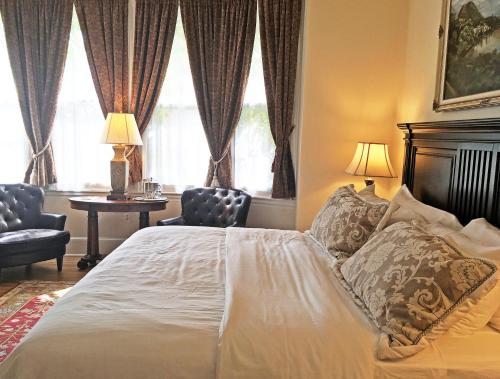 a bedroom with a bed and two chairs and a window at Morris House Hotel in Philadelphia